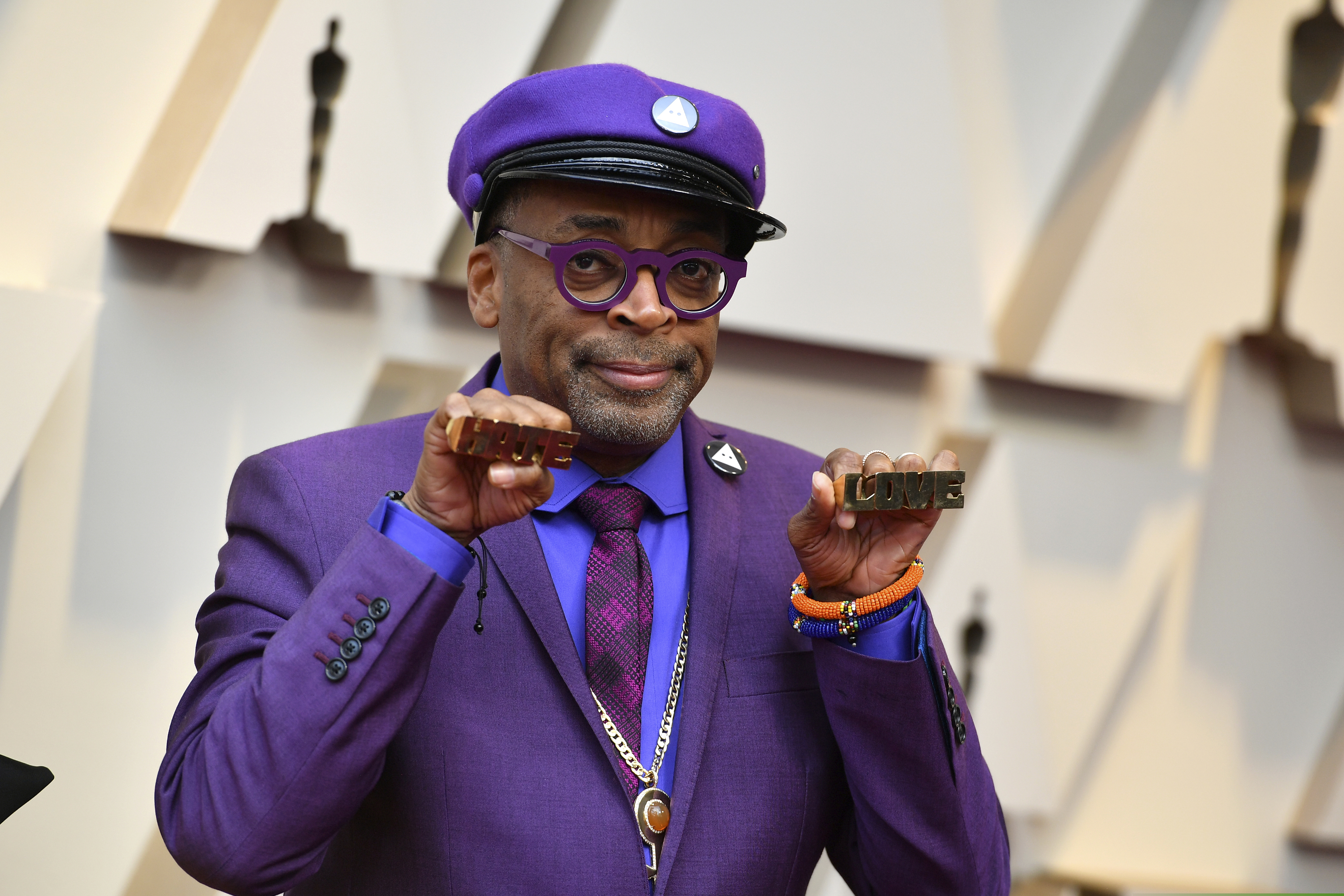 Spike Lee holds up brass knuckles reading "hate" and "love" from his iconic film "Do The Right Thing" as he arrives at the Oscars on Sunday, Feb. 24, 2019, at the Dolby Theatre in Los Angeles.