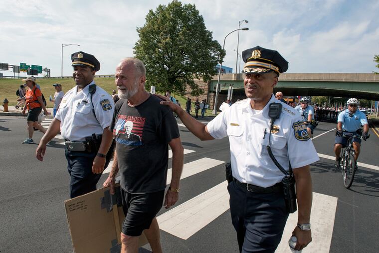 Philadelphia Police Commissioner Richard Ross (right) thanks Bruce Eichbauer, 68, Nashville, Tenn., who complimented him for the way the Philadelphia police officers were treating the Bernie Sanders supporters as they marched down Broad Street to FDR Park.