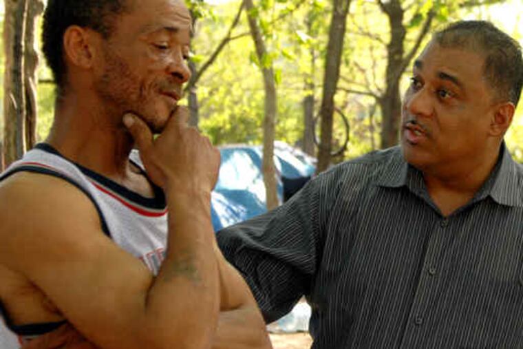The self-appointed "mayor" of Transition Park, Lorenzo "Jamaica" Banks (left), talks with Camden County official Gino Lewis. "You get a peace of mind being here," Banks says.