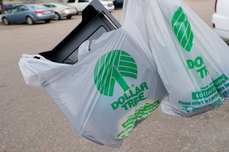 A customer exits a Dollar Tree store holding a shopping bag in 2022 in Jackson, Miss.