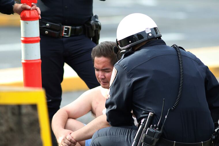 Security forces attend to an unidentified male outside the the main gate at Joint Base Pearl Harbor-Hickam on Wednesday after a shooting.
