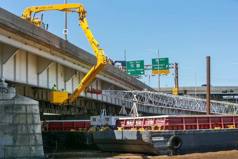 Inspectors examine the Vine Street Expressway bridge over the Schuylkill River after a barge floated into during heavy rain from Tropical Storm Isaias in August 2020.