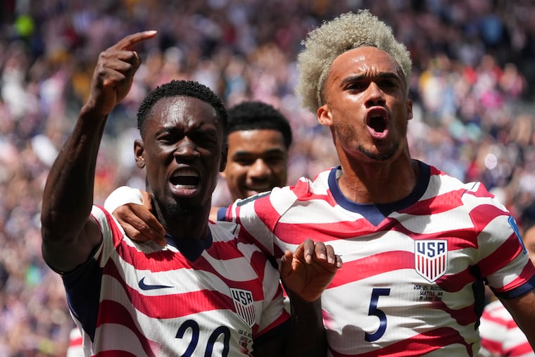 Folarin Balogun (left) celebrates with Antonee Robinson after forcing the early Australian own goal that opened the scoring on Friday in Seattle.