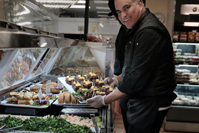 Carlino’s Market executive chef Alejandro Perez puts tray of filet mignon (herb and garlic crusted beef tenderloin with a side of creamy horseradish sauce) into the homemade prepared foods case at Carlino’s Market in Ardmore on Friday, Feb. 13, 2026.