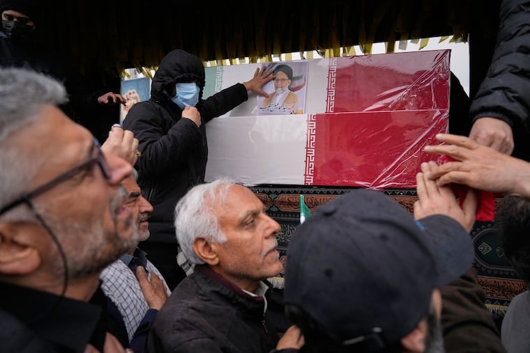 Iranians reach toward the coffins as they follow the funeral procession of Iran's intelligence minister Esmail Khatib and, according to Iranian officials, his wife and daughter, in Tehran, Iran, Friday, March 20, 2026.