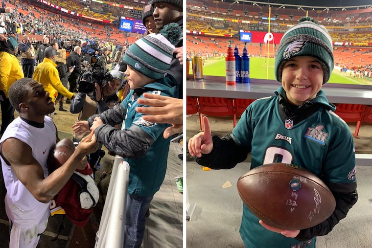 Eagles wide receiver Nelson Agholor signs a football for Cohen Zechman, a 10-year-old Eagles fan who went viral for giving Nate Sudfeld the football from the quarterback's first touchdown pass back.