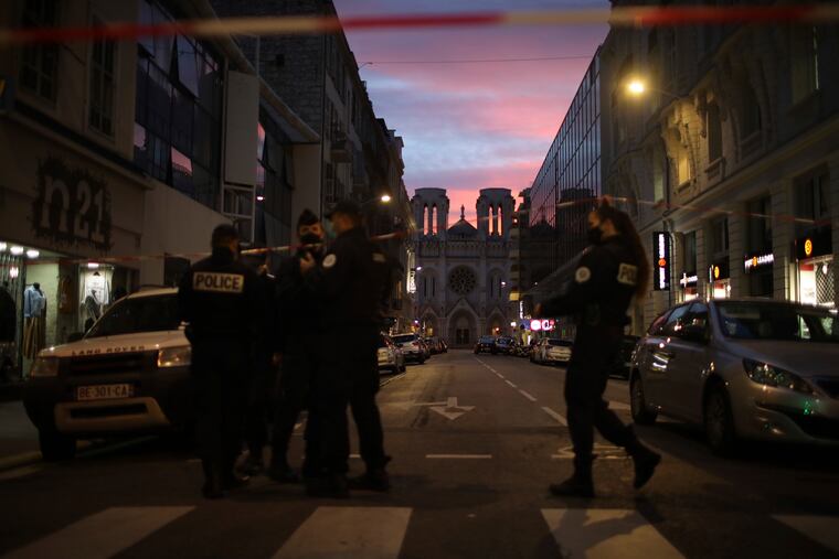 Police work behind a restricted zone near the Notre Dame church in Nice, southern France, after a knife attack.