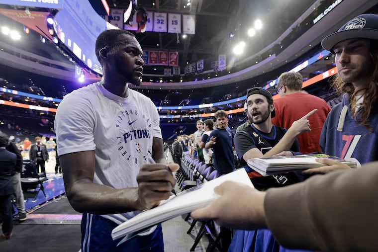 Paul Reed signs autographs for fans prior to his Detroit Pistons facing his former team, the Philadelphia 76ers, at the Wells Fargo Center earlier this season.