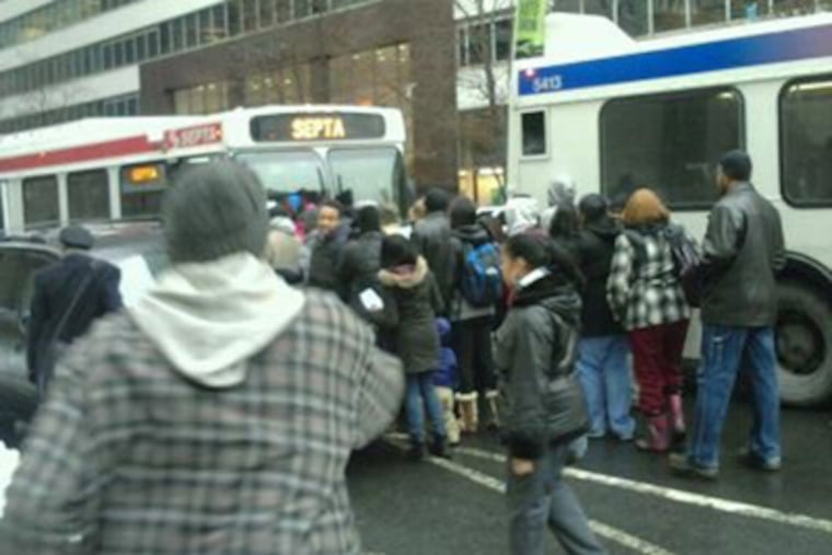 On Market Street near 15th Street, across from City Hall, passengers move toward a free SEPTA shuttle bus that will take them north along Broad Street, after the Broad Street subway was shut down Tuesday afternoon. (Howie Shapiro / Staff)
