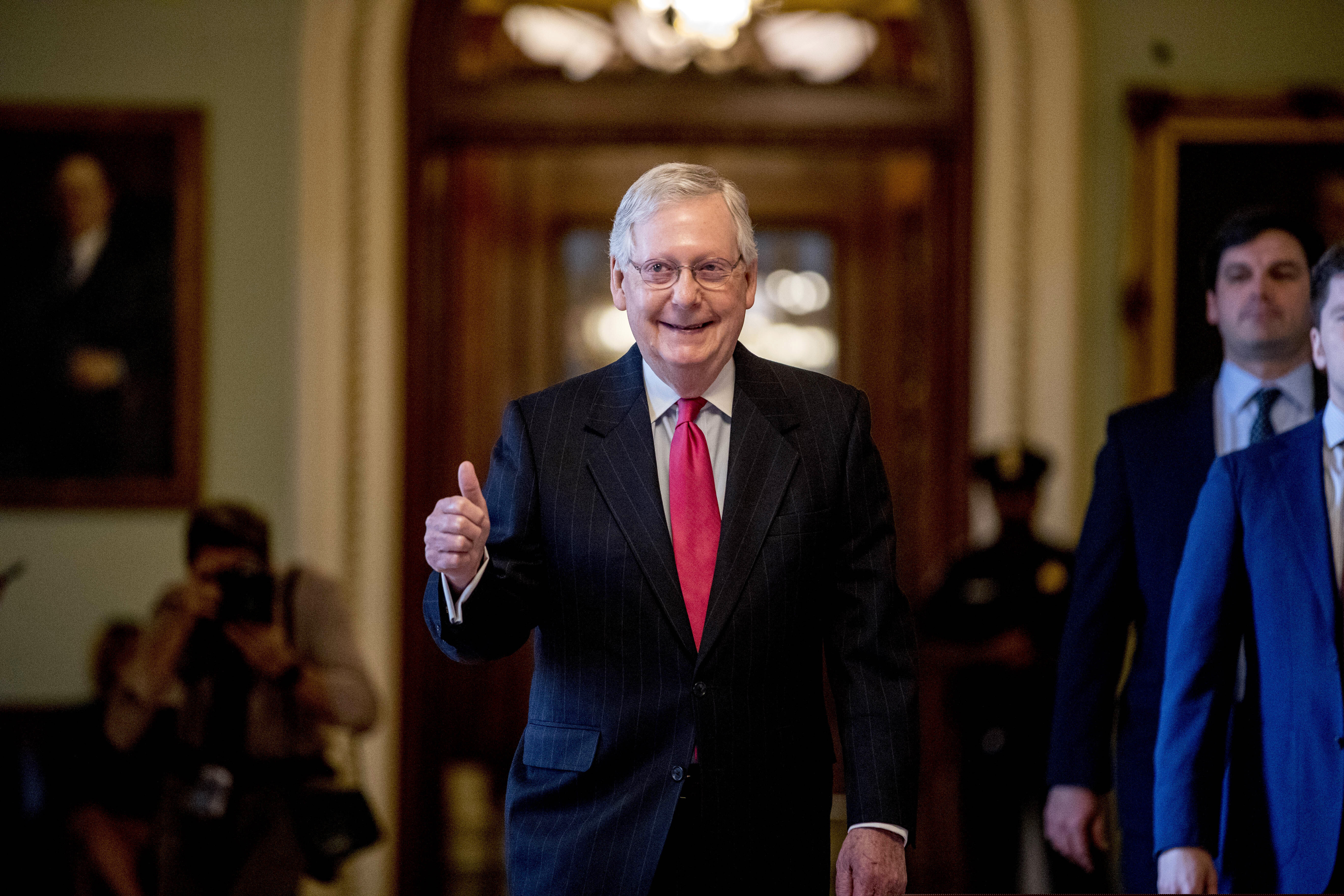 Senate Majority Leader Mitch McConnell gives a thumbs-up Wednesday as he leaves the Senate chamber on Capitol Hill in Washington, where a deal has been reached on a coronavirus bill.