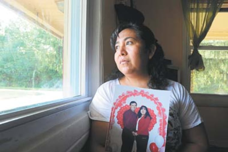 Ibed Mendoza, 37, clutches a photo of herself and husband Concepcion Mendoza, 39. Concepcion was deported to Mexico after 19 years of marriage in the United States, where they worked and raised three boys. ( SHARON GEKOSKI-KIMMEL / Staff Photographer )