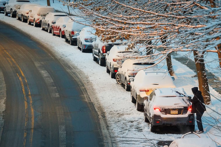 A driver removes snow from a car before pulling away from a parking spot after an overnight snowfall covered streets and vehicles on Wednesday. Could something bigger happen next week?
