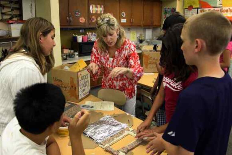 Teacher Kelly Crits helps students with the solar energy project at General Nash Elementary School in Harleysville.