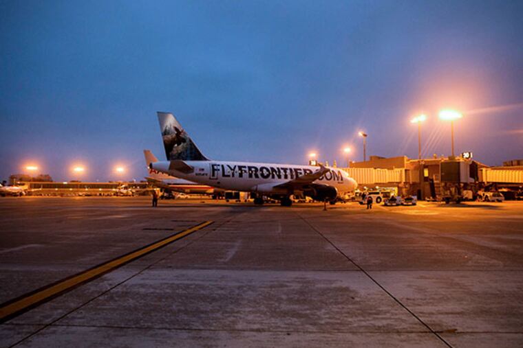 A Frontier Airlines Holdings Inc. airplane sits on the tarmac at San Diego International Airport in San Diego, California, U.S. on Thursday, Sept. 19, 2013. Airlines must reconsider buying new or used aircraft as rising interest rates increase ownership costs, which could outweigh fuel savings at lower prices. (Sam Hodgson/Bloomberg)