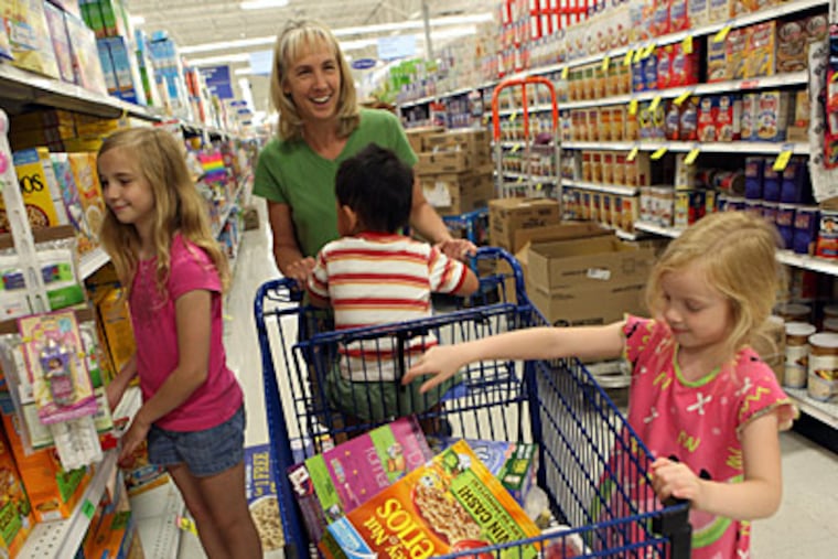 Tamara Waldschmidt, with son Nathan, 3, in her cart, gives daughters Kimberly, 5, and Alexis, 10, a few cereals to pick from at a store in Bolingbrook, Ill. Waldschmidt uses the store’s nutritional scoring system to guide her buying. (David Pierini/Chicago Tribune/MCT)
