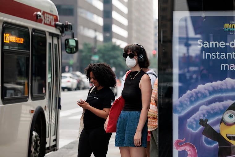 Penn State graduate student Ray Boone waits for the bus with a face mask on because of the air quality on Thursday.