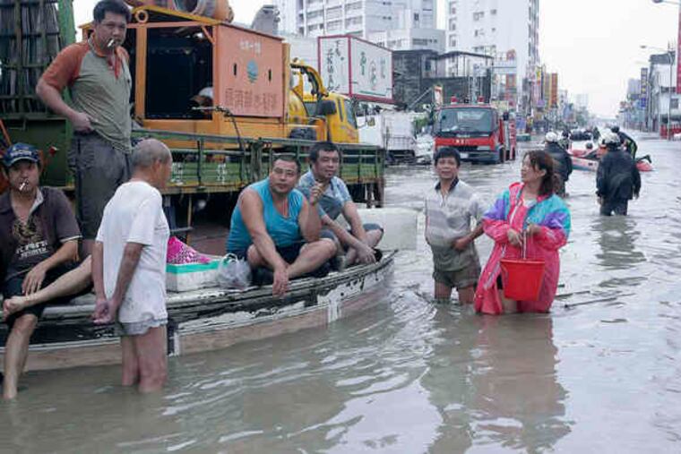 People gathered in Chiatung Town in southern Taiwan yesterday after Typhoon Morakot hit over the weekend. The storm dumped 80 inches of rain, the worst flooding in the region in 50 years.