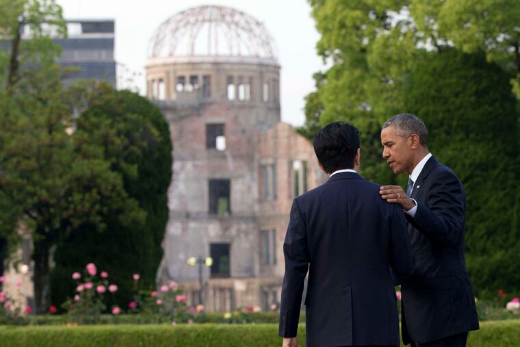 President Obama speaks with Japanese Prime Minister Shinzo Abe, with the Atomic Bomb Dome seen at rear, at the Hiroshima Peace Memorial Park. Obama is the first sitting U.S. president to visit the site.