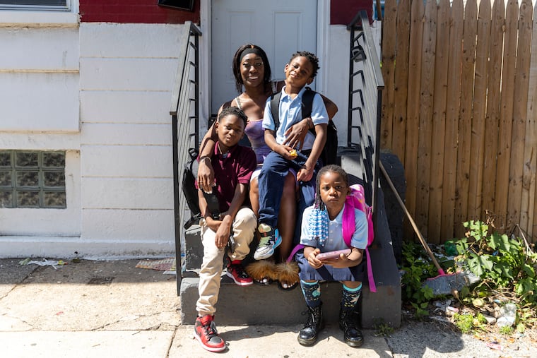 Jasmine Albury, of North Philadelphia, Pa., poses for a photo with her kids, Kylie, 8, 3rd Grade, (right), Josiah, 9, 4th Grade, (left), and Joshua, 6, 1st Grade, (center), at their home in Philadelphia, Pa., on Saturday, Sept., 10, 2022.
