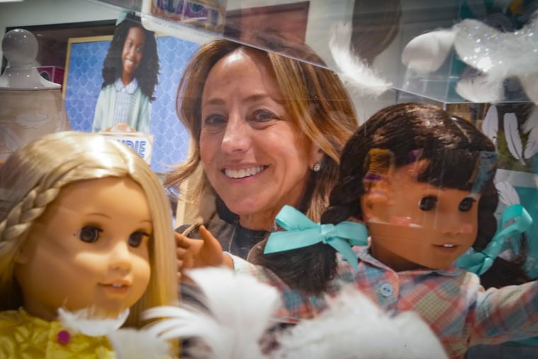 Jamie Cygielman, general manager and president at American Girl, poses behind a showcase of dolls during a press tour earlier this month.