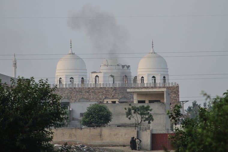 Local residents stand outside a mosque of an Islamic seminary partially damaged by a suspected Indian missile attack, outskirts of Bahawalpur, Pakistan, on Wednesday, May 7, 2025.