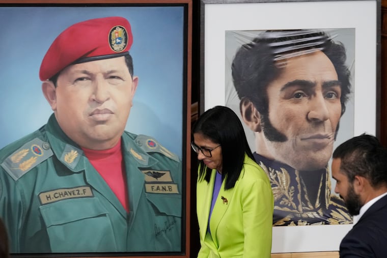 Venezuela's acting President Delcy Rodriguez walks past a image of former President Hugo Chavez, left, and Independence hero Simon Bolivar at the National Assembly in Caracas, Venezuela, Jan. 15, 2026.