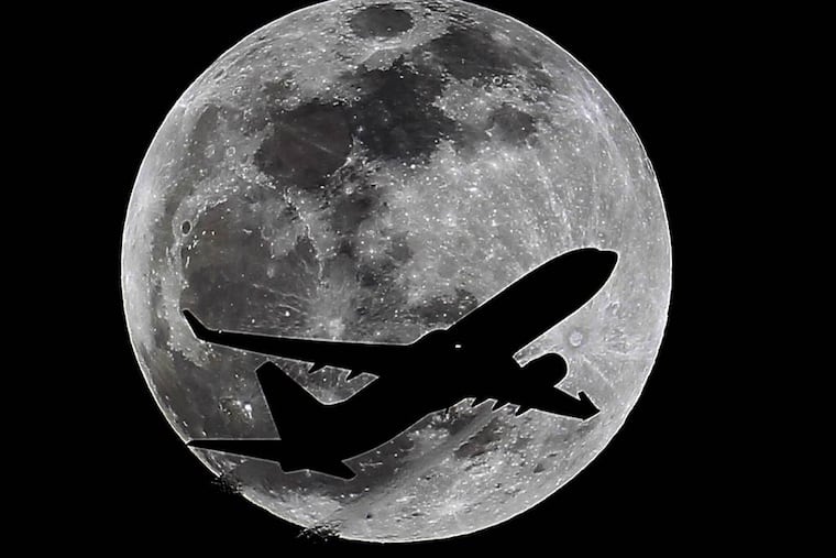 An airliner crosses the moon's path, Monday, April 14, 2014, above Whittier, Calif., approximately one hour before a total lunar eclipse. Then, on April 29, the Southern Hemisphere will be treated to a rare type of solar eclipse. In all, four eclipses will occur this year, two lunar and two solar. (AP Photo/Nick Ut)