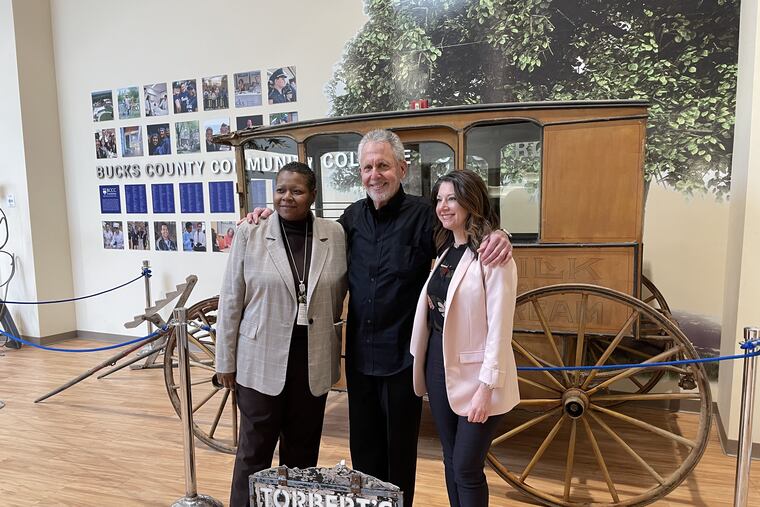 Gene Epstein (center) with college president Felicia L. Ganther (left), and Christina Kahmar (right) on Bucks County Community College's Newtown campus, after donating an original dairy wagon to display in January 2023.