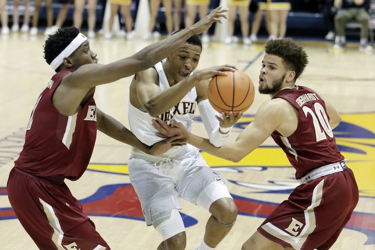 Drexel’s Troy Harper splits Elon defenders Dmitri Thompson (left) and Sheldon Eberhardt on his way to the net in the 2nd half of the Elon at Drexel University mens basketball game on January 25.