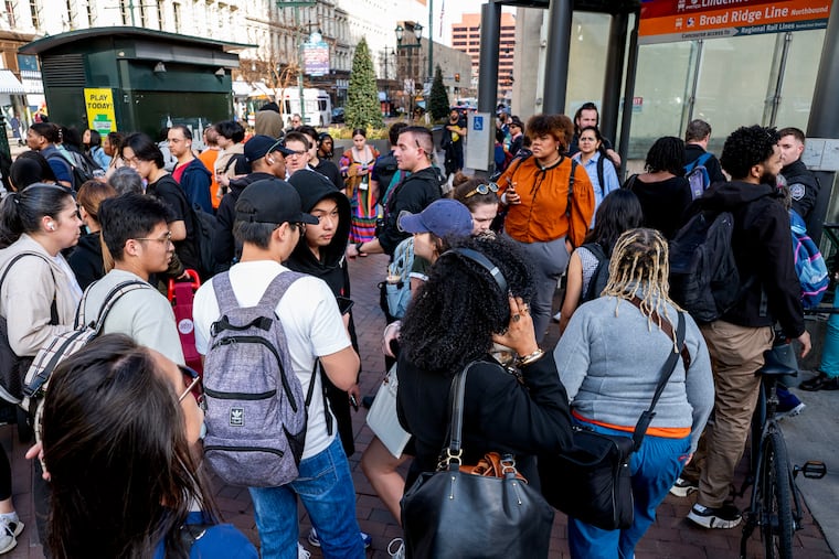 SEPTA commuters gather outside the subway entrance at Eighth and Market Streets on Wednesday as a power outage shut down the L, formerly known as Market-Frankford Line, between 30th Street and Spring Garden station.