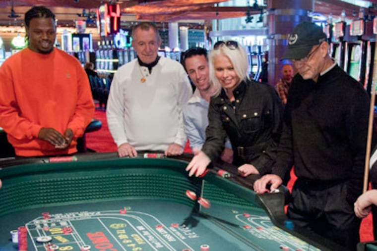 Julie Radyn, 29, and her friend Samuel Lassoff, 32, both of Northeast Philadelphia, try their luck at a craps table of the new Revel Casino and Resort in Atlanta City Monday, April 2, 2012. The doors opened at 7 a.m. to gamblers at the start of an 8-week preview before the official grand opening Memorial Day Weekend. ( Clem Murray / Staff Photographer )