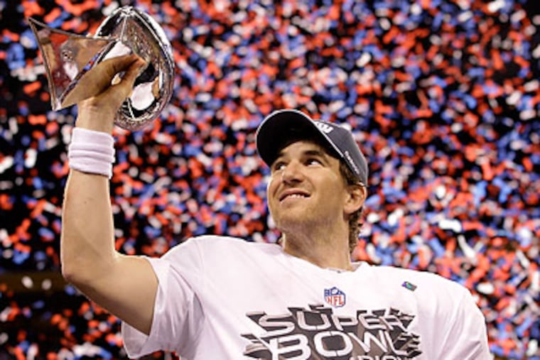 Eli Manning raises the Vince Lombardi Trophy after leading the New York Giants to a win in the Super Bowl. (David J. Phillip/AP)