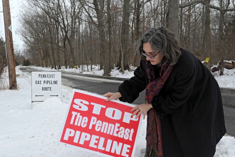 Alix Bacon adjusts an anti-pipeline placard in January 2015 in Hunterdon County, N.J., near where the proposed PennEast pipeline, considered in April by the U.S. Supreme Court, would cross the road.