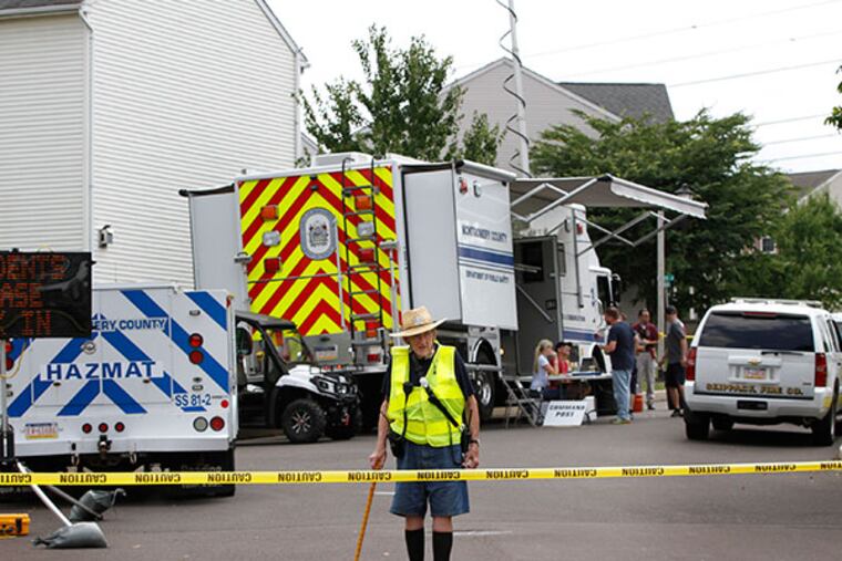 Ellis Kriebel of the Harleysville Fire Police mans a road block in the development near the command center in Skippack while officials investigate the source of an odor that forced evacuations Sunday night. ( MICHAEL S. WIRTZ / Staff Photographer )