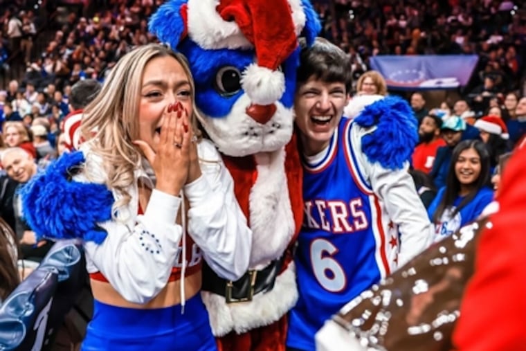 Jackie Murtha, Franklin the Dog, and Chris Girard after Girard proposed to longtime girlfriend Murtha at the Sixers-Clippers game on Dec. 24, 2022 at the Wells Fargo Center.
