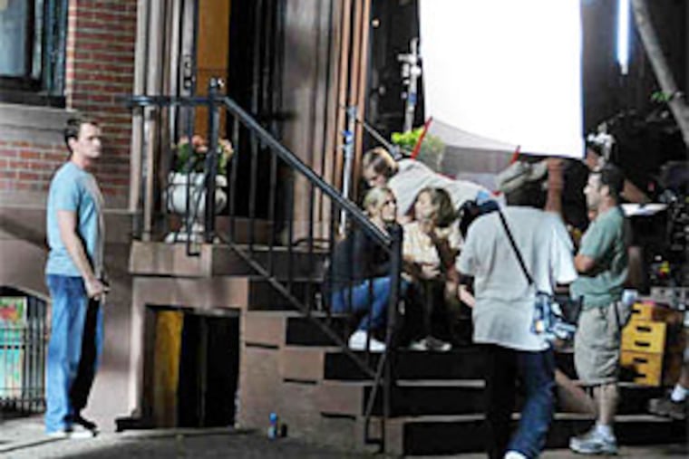 Neil Patrick Harris (left) waits during a break in the filming of "The Best and the Brightest" in the 2000 block of Delancey Place. On the steps Saturday were Bonnie Somerville (left) and Amy Sedaris. (Hughe Dillon / For The Inquirer)
