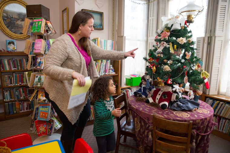 Meredith Rumer and daughter Bianca, 4, examine holiday decorations at the Ryerss Museum and Library in Philadelphia's Burholme Park. The house and its residents have played a role in local history.