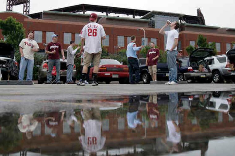 Happy to be part of the Phillies scene, Jenny Monaghan (left) and Sarah Beabout, University of Delaware students, play beer pong yesterday.