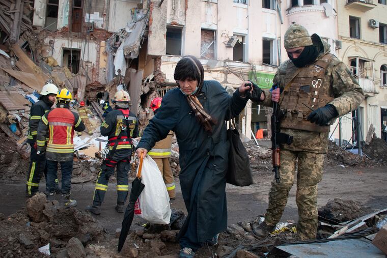 A volunteer of the Ukrainian Territorial Defense Forces helping a woman to cross the street in Kharkiv, Ukraine, on Wednesday.