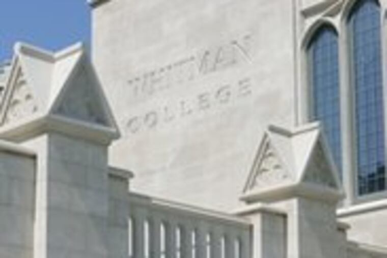 A worker adds final touches to Whitman College, a $136 million complex of dorms, gallery and theater.