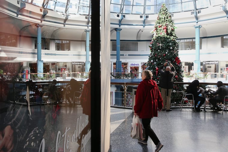 Shoppers walk past the Christmas Tree in the rotunda of the Shops at Liberty Place in Center City on Thursday, Dec. 7, 2017.
