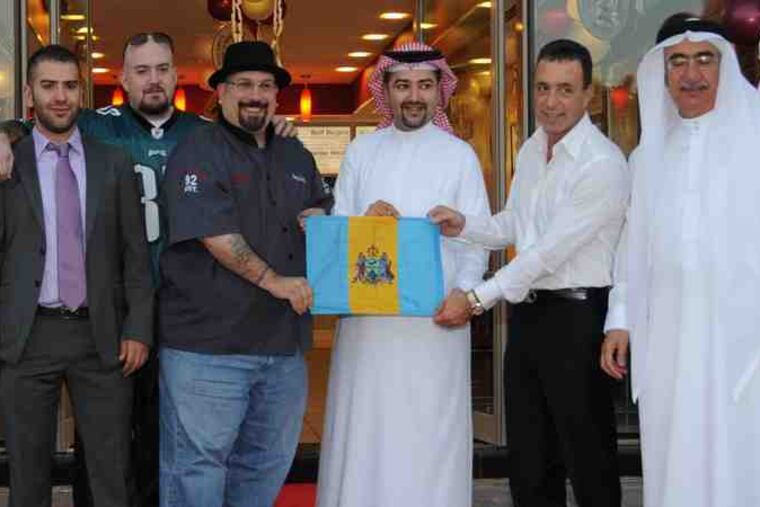 A long way from South Philly, Tony Luke Jr. (center) was surrounded by dignitaries at the grand opening of his sandwich shop in East Riffa,in the Middle Eastern Kingdom of Bahrain, last Sunday.