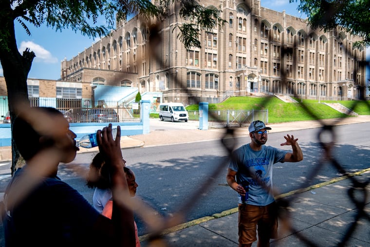 Olney High School principal Michael Roth talks with student athletes including senior Sidi Traore (left) following a lacrosse practice. The school’s sports facilities are in deplorable condition. The community rallied to draw attention to their plight, and the district came forward with $7m to start fixing things.
