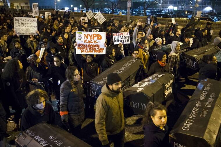 FILE - In this Dec. 4, 2014, file photo, protesters carry signs criticizing the police, and replicas of coffins during a march over the Brooklyn Bridge to protest a grand jury's decision not to indict the police officer involved in the death of Eric Garner, in New York. No firm statistics can say whether a spate of officer-involved deaths is a growing trend or simply a series of coincidences. (AP Photo/John Minchillo, File)