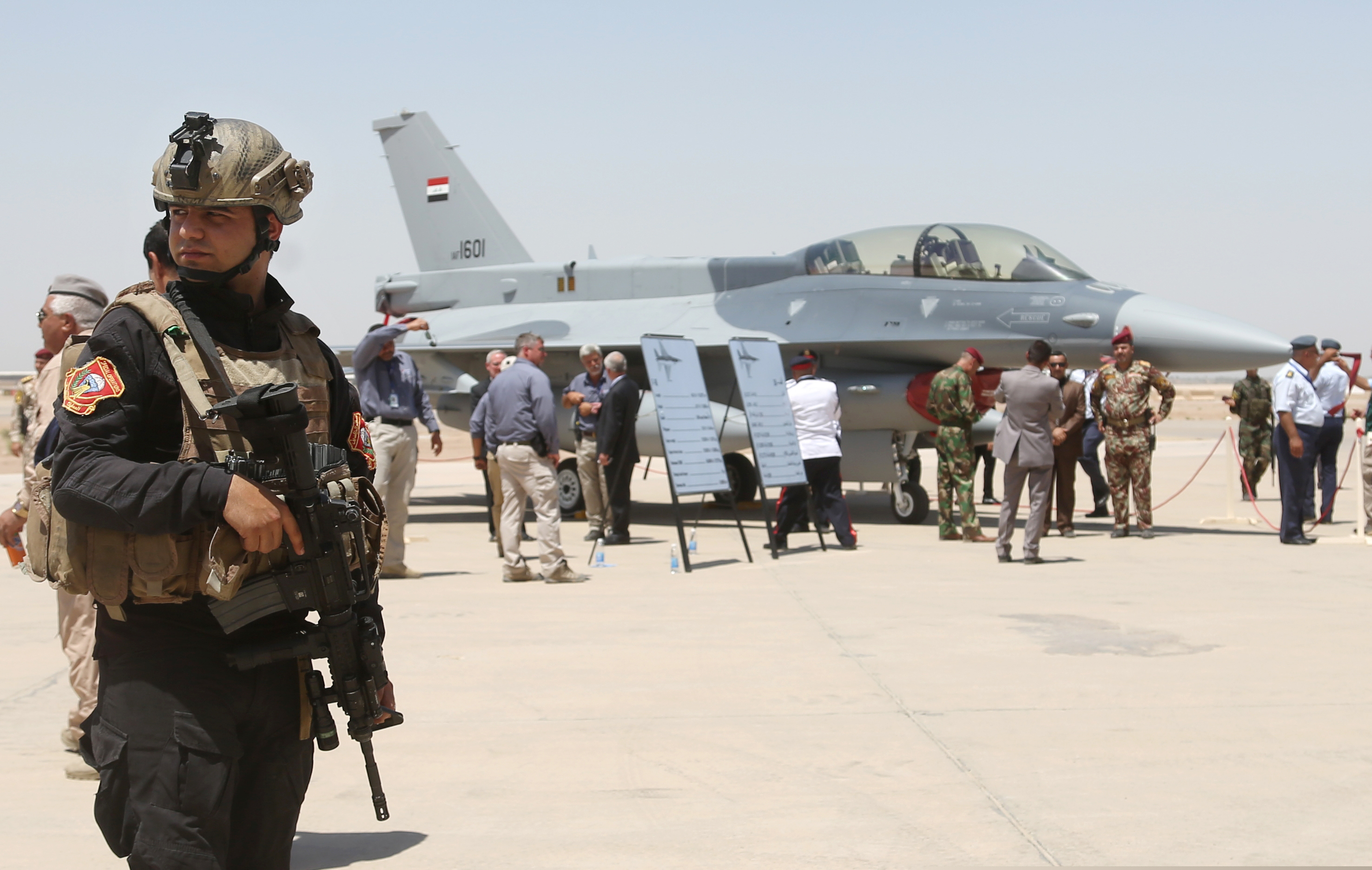 In this Monday, July 20, 2015 file photo, a member of the Iraqi SWAT team stands guard as security forces and others gather next to a U.S.- made F-16 fighter jet during the delivery ceremony at Balad air base, Iraq. Security measures have been increased at one of the country’s largest air bases that houses American trainers, following an attack last week, a top Iraqi air force commander said Saturday, June 22, 2019 while the U.S. military said operations at the base are going on as usual and there are no plans to evacuate personnel at the present time.