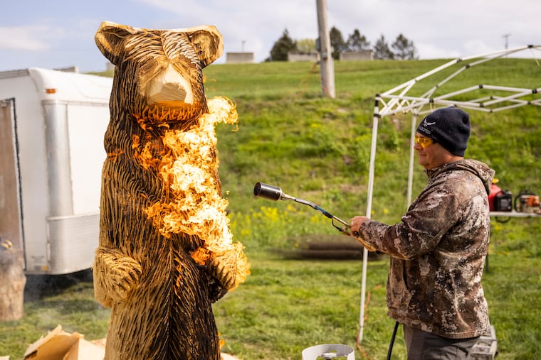 Ben Rannels, of Altoona, Pa., uses a flame to burn off excess wood and give visual texture to his 7 foot bear at the Central PA Chainsaw Carving Competition at the Shippensburg Fairgrounds in Shippensburg, Pa., last week.