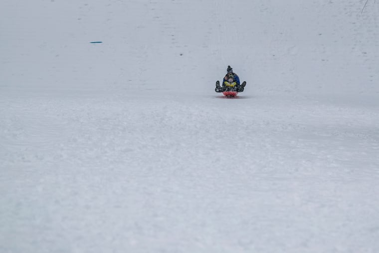 People sled down the Philadelphia Museum of Art steps in this 2021 file photo. As the region braces for a major snowstorm, the Philadelphia School District has already called a virtual learning day Monday.
