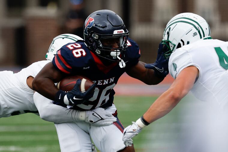 Penn wide receiver Issac Shabay (center) runs with the football against Dartmouth cornerback Tyson McCloud (left) and linebacker Macklin Ayers during a game at Franklin Field last month.