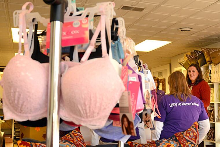 Earlier this year, Joanie Balderstone (not shown) and Rebecca McIntire (back to camera) launched Distributing Dignity, a nonprofit that collects feminine hygiene products and bras for women in homeless shelters. They meet with Bridget McMullin (far right) at her business, McMullin Design Group in Haddonfield October 27, 2014, who has joined their campaign for the month of November to raise awareness for the nonprofit. ( TOM GRALISH / Staff Photographer )