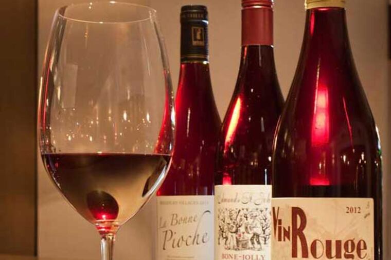 A pour of Clos de Tue-Boeuf and its bottle in the foreground with bottles of Bone Jolly and La Bonne Pioche, at a.bar.